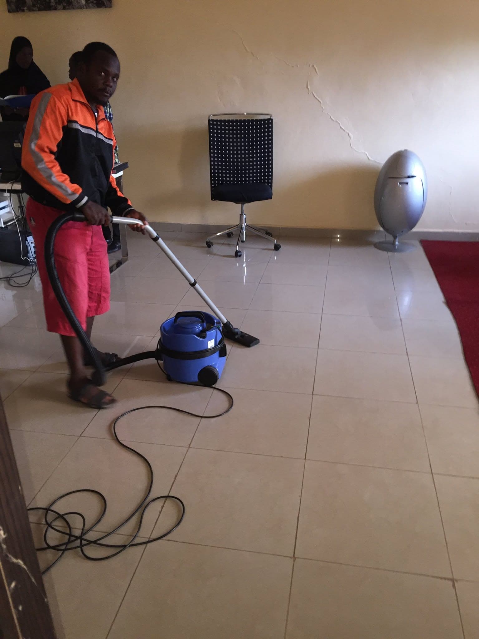 Un agent IKnett passe l'aspirateur dans un bureau, à Bamako.