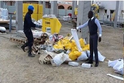 Deux agents devant des gravats et des sacs à évacuer sur un chantier