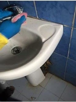 Nettoyage d'un lavabo à l'éponge, gants de protection